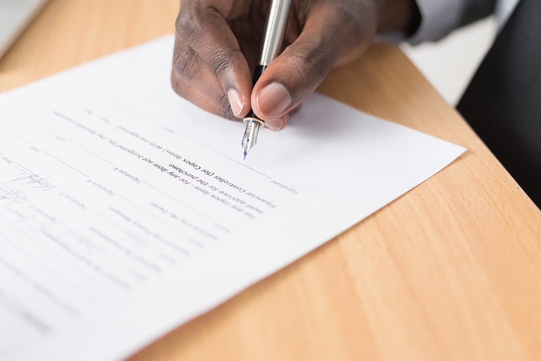 Person signing a rental lease agreement at a desk